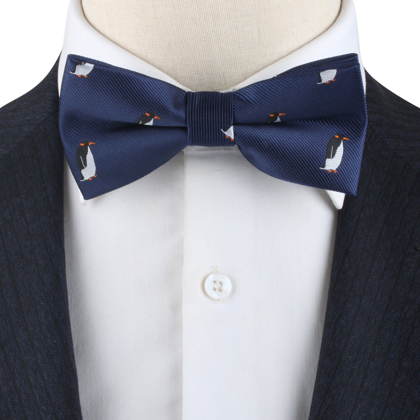 Close-up of a person wearing a Penguin Bow Tie, a white dress shirt, and a dark suit jacket, exuding cold elegance.