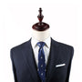 A dark blue pinstripe suit with a white dress shirt and a Penguin Slim Tie is displayed on a mannequin, exuding timeless elegance.