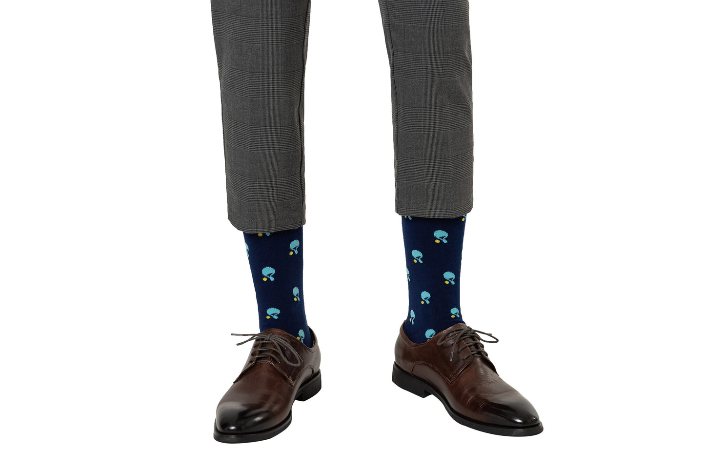 A person wearing cropped gray dress pants, dark brown dress shoes, and Table Tennis Socks featuring a navy blue mushroom pattern made from breathable fabric.