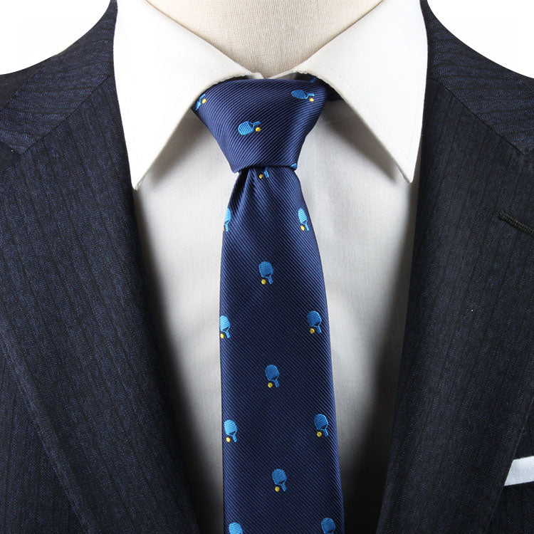 Close-up of a person in a navy pinstripe suit wearing a white shirt, with a Pickle Ball Necktie, exuding refined charm.
