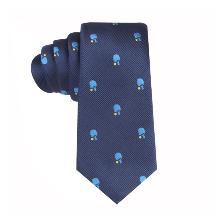 A Pickle Ball Thin Tie with a pattern of small blue and yellow objects, possibly penguins or abstract designs, evenly distributed across the fabric exuding refined charm.