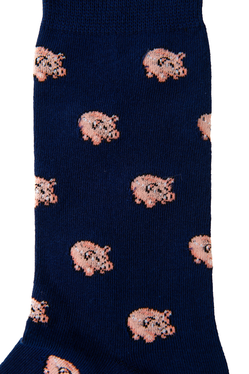 The "Piggy Bank Socks" in navy blue feature a delightful pattern of small pink pig illustrations, merging comfort with style effortlessly.