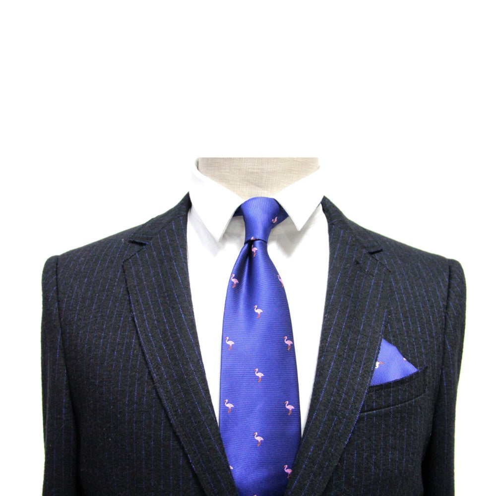 A headless mannequin dons a pinstripe suit with a white shirt and blue tie featuring pink flamingos, complemented by the Navy Pink Flamingo Pocket Square that perfectly aligns with the vibrant tropical theme.