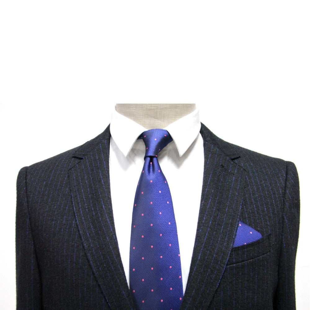 A mannequin showcases formalwear in a dark pinstripe suit with a white shirt, blue tie featuring pink polka dots, and the stylish Navy Pink Polka Dot Pocket Square, making it ideal for any men's fashion accessory enthusiast.
