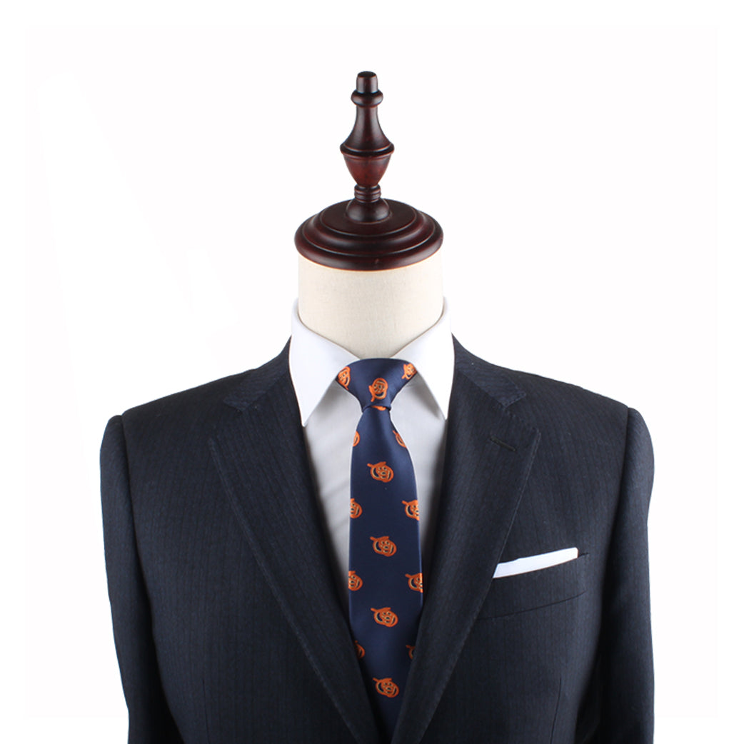 A suit on a tailor's mannequin, featuring a navy blue Pretzel Slim Tie with an orange floral twist, paired with a white dress shirt and a dark blazer adorned with a white pocket square.