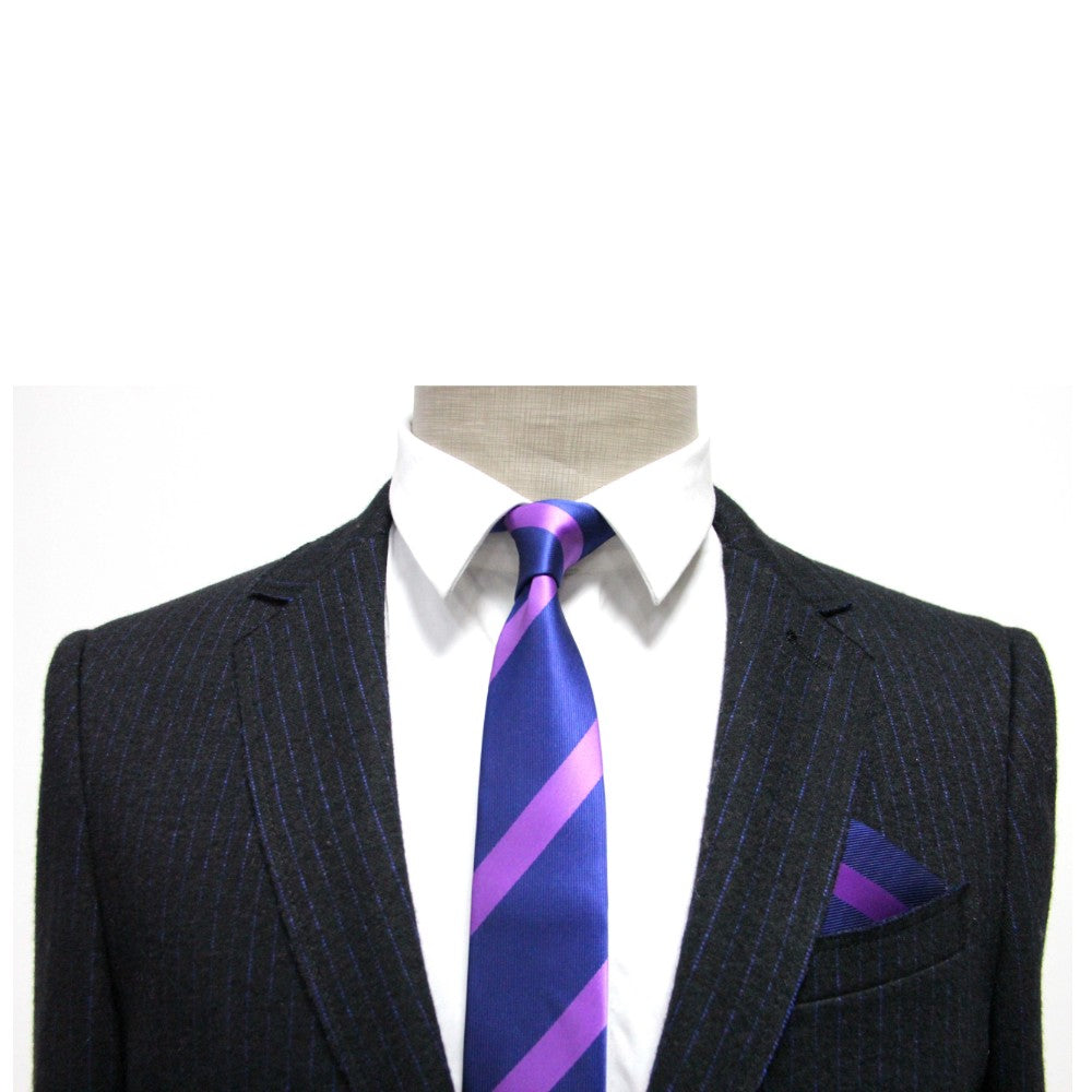A person wearing a dark pinstripe suit, white dress shirt, and the Navy Purple Stripe Skinny Tie with a matching pocket square.