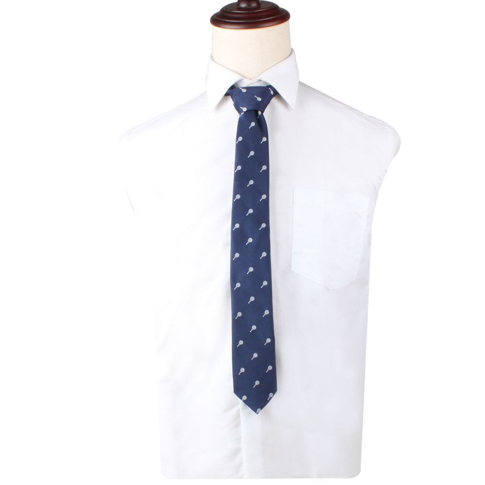 A white dress shirt paired with the Racket Print Tie, a navy blue tie featuring small white airplane patterns, exuding timeless refinement, displayed on a white mannequin torso.
