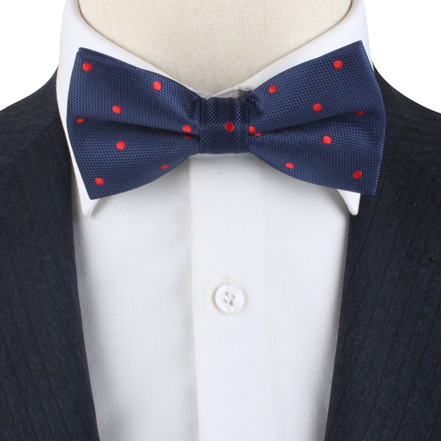 Close-up of a person wearing the Red Polka Dot Bow Tie paired with a crisp white dress shirt and a dark suit jacket.