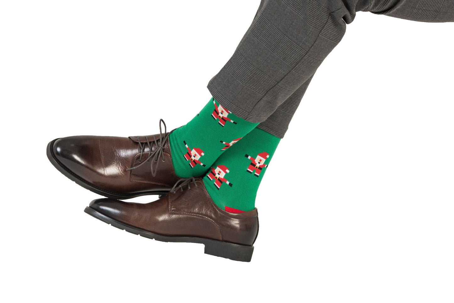 The person wearing grey pants, brown dress shoes, and a pair of "Santa Socks," is adding a touch of holiday cheer to their attire with the green socks featuring a Santa Claus pattern.