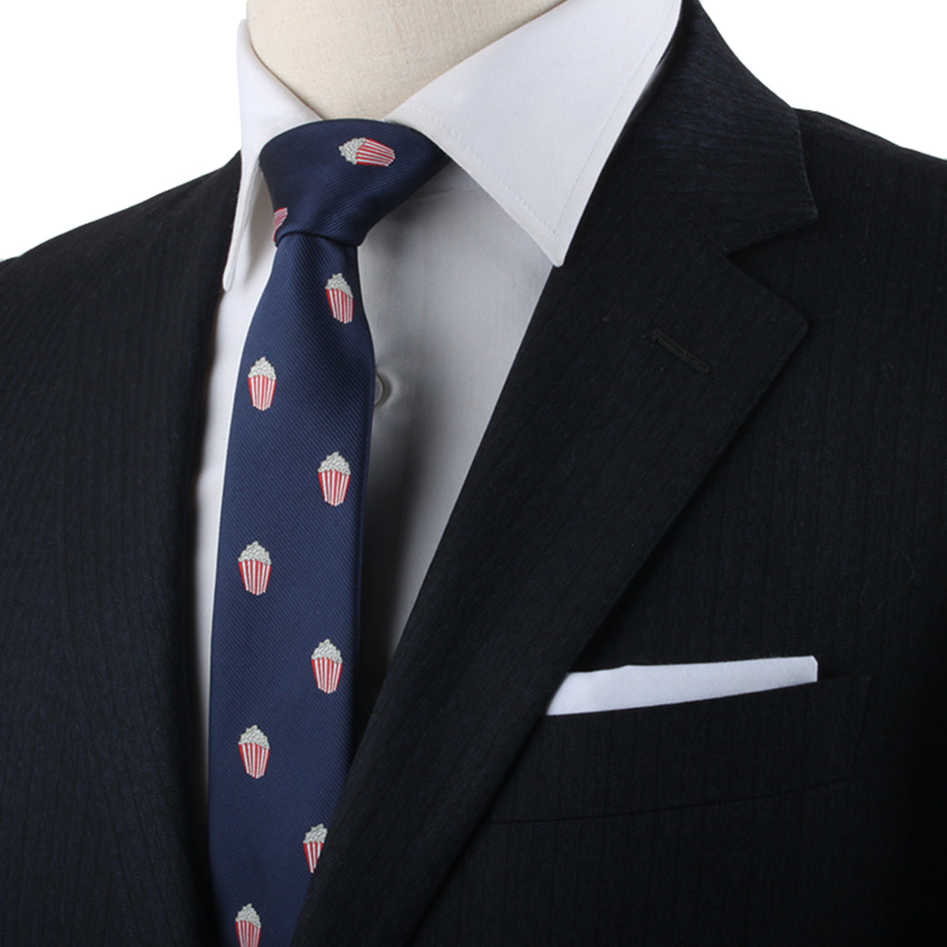 Close-up of a person wearing a black suit with a white shirt and a Red and White Striped Tie, showcasing their cinematic style.