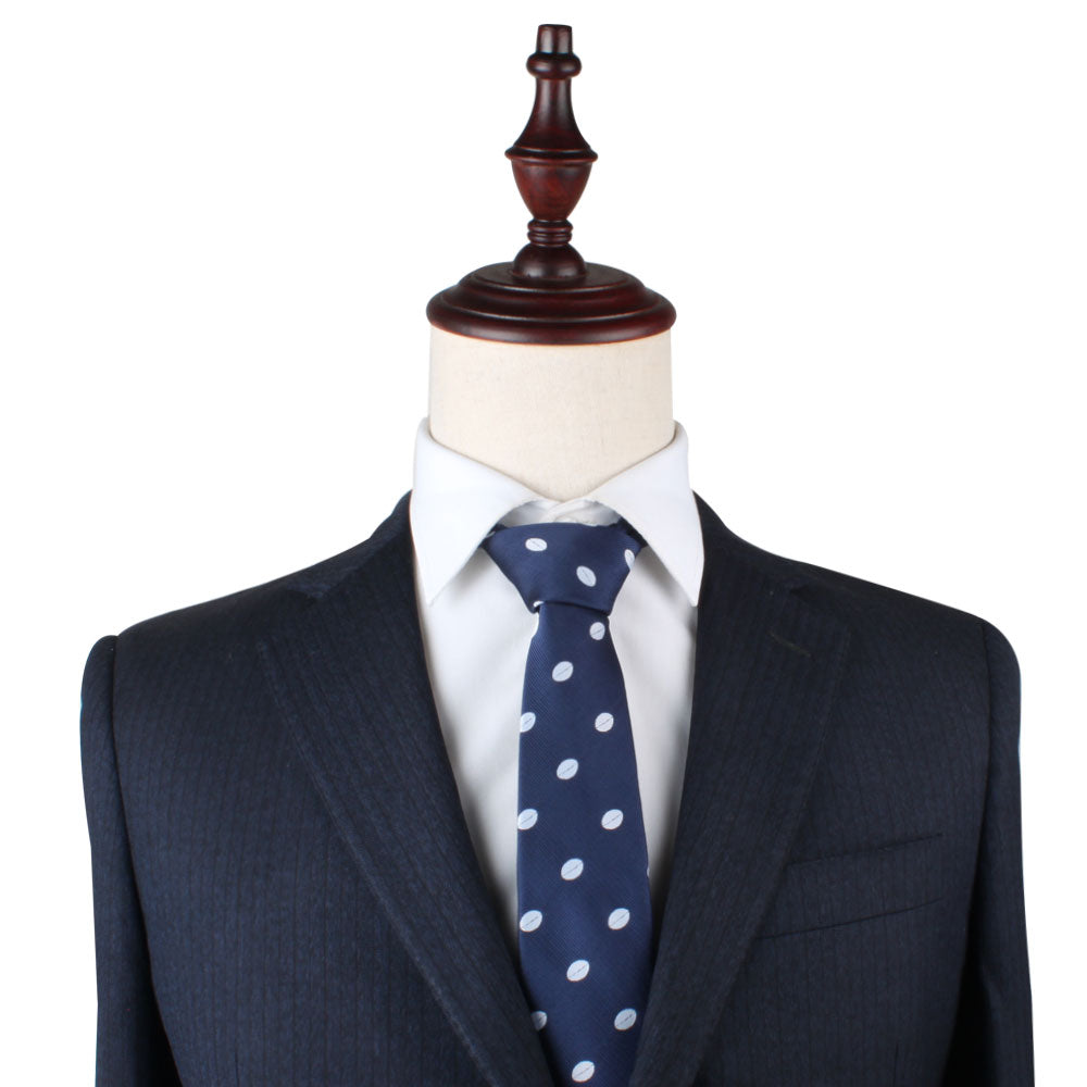 A headless mannequin dressed in a navy blue suit and white shirt, accessorized with a Rugby Slim Tie.