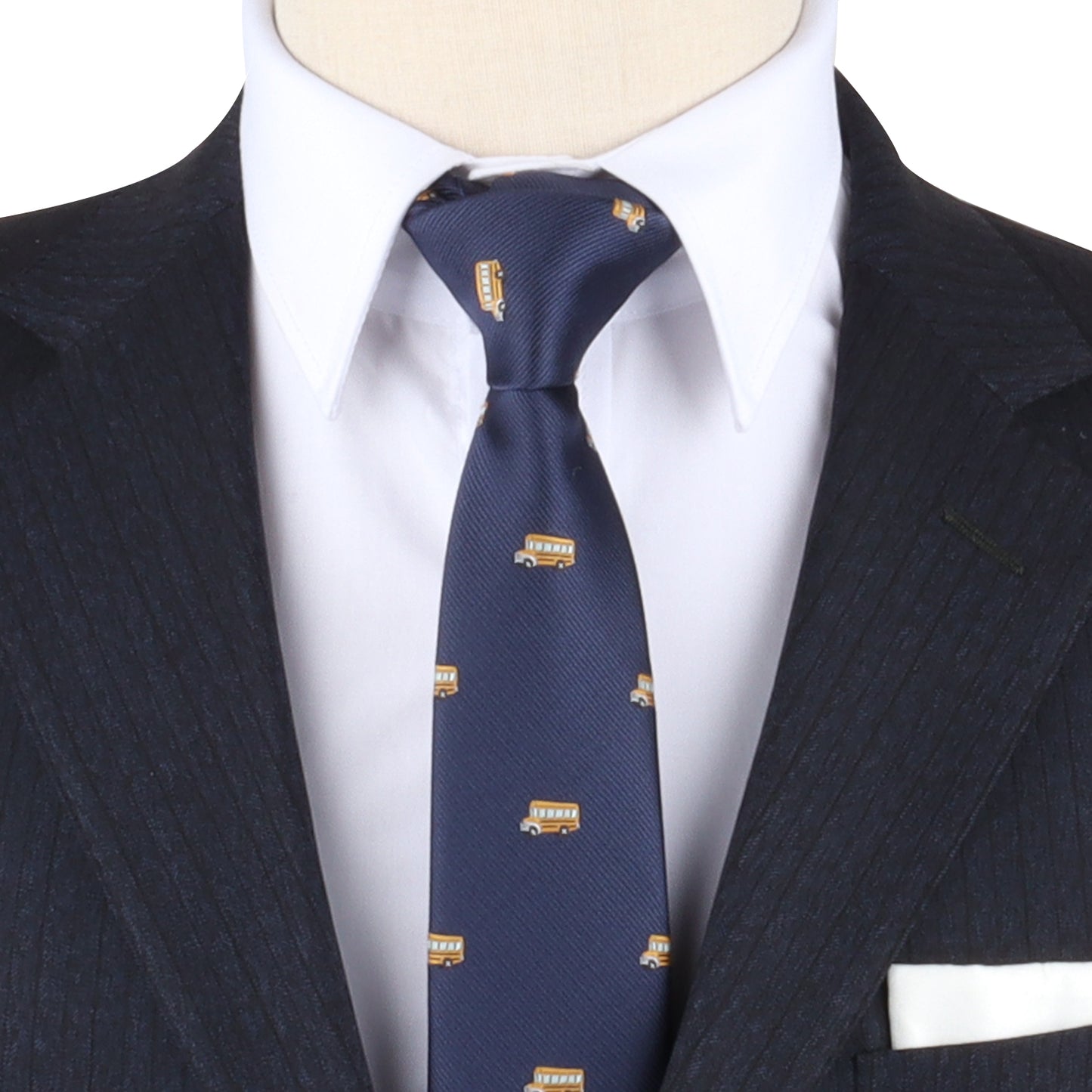 Close-up of a mannequin wearing a dark suit, white shirt, and a School Bus Pattern Tie styled as a nostalgic tie.