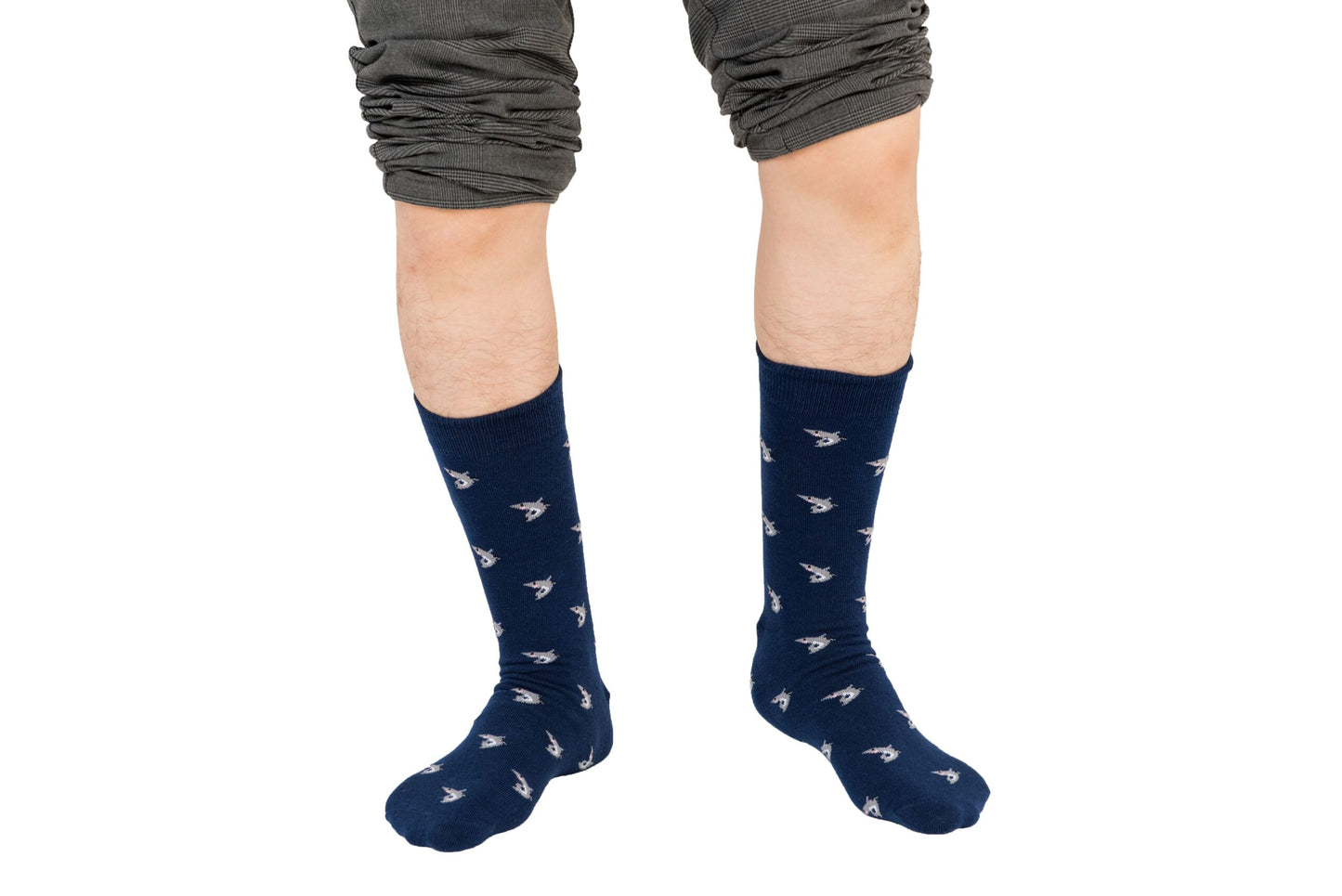 Person showcasing a deep-sea style with Shark Socks, featuring dark blue hues and small white designs, paired with rolled-up gray pants.