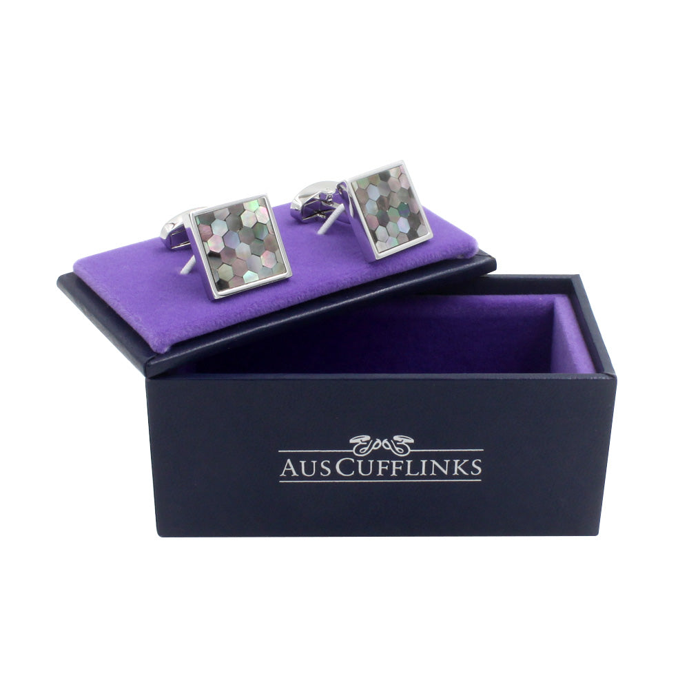 A pair of Signature Malachite Cufflinks on a purple interior of a black box with the logo "auscufflinks" printed on the side, showcasing stellar design.