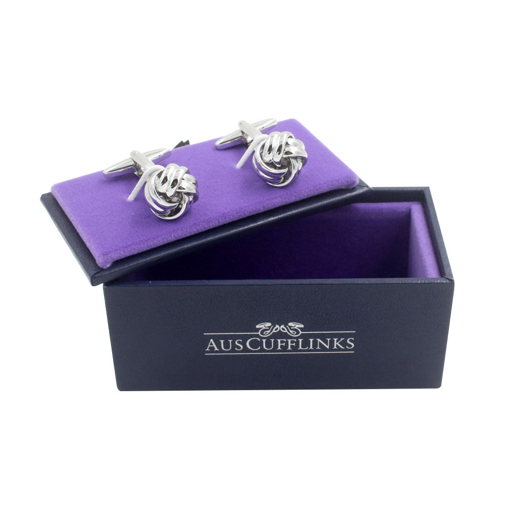 A pair of Silver Knot Cufflinks, showcasing a sophisticated style, is displayed in an open purple and black box labeled "AUSCUFFLINKS." This product description highlights the elegant design perfect for any occasion.