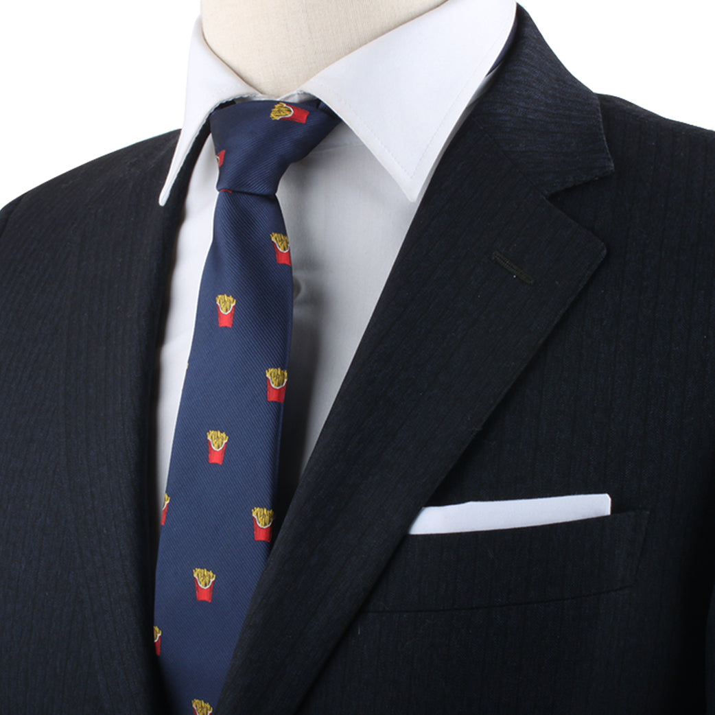 Close-up of a person wearing a black suit jacket, white dress shirt, and the Snack Lover Tie, showcasing its unique pattern of small red French fry containers. The suit jacket features a white pocket square, adding an element of culinary charm to the modern sophistication.