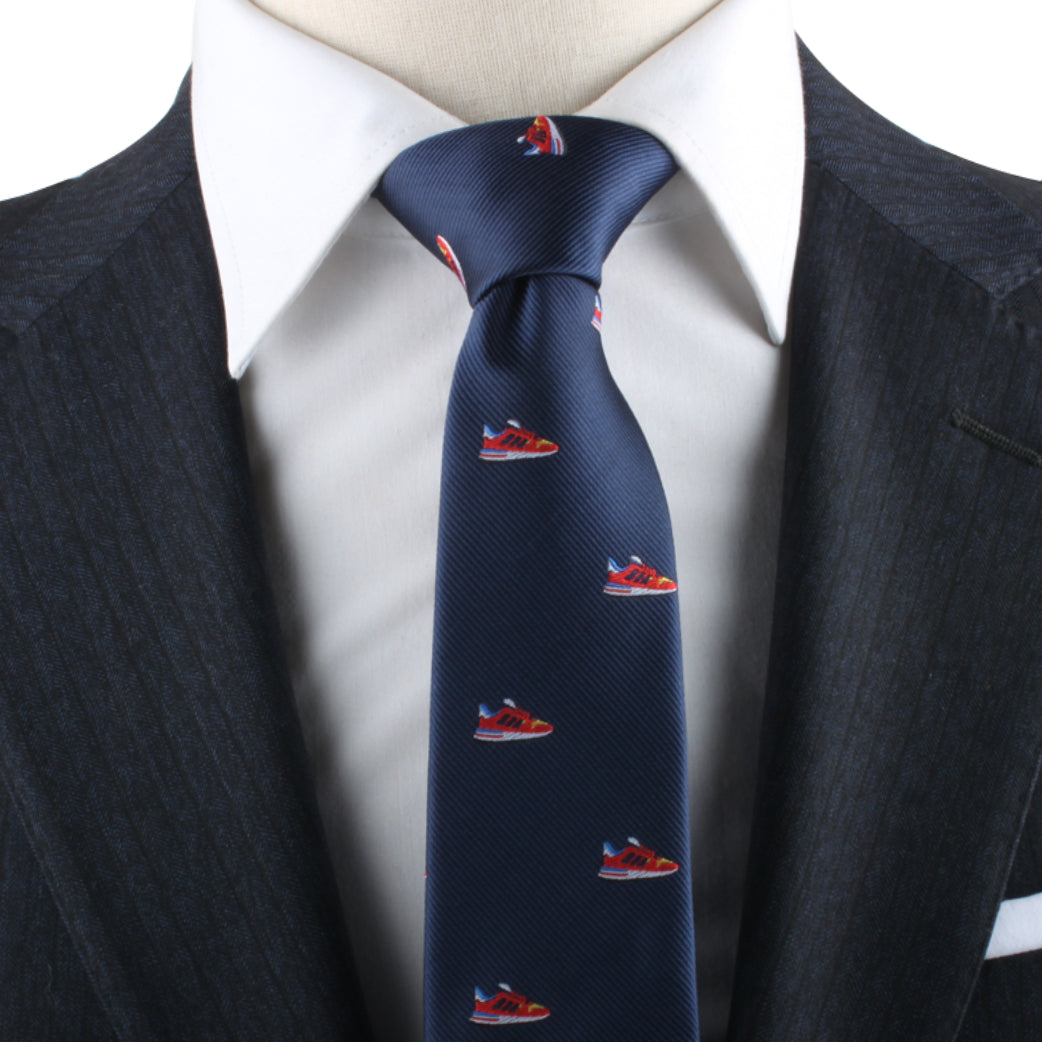 Close-up of a person wearing a dark pinstripe suit with a white shirt and a Sneaker Necktie, adding an urban flair to their modern style.