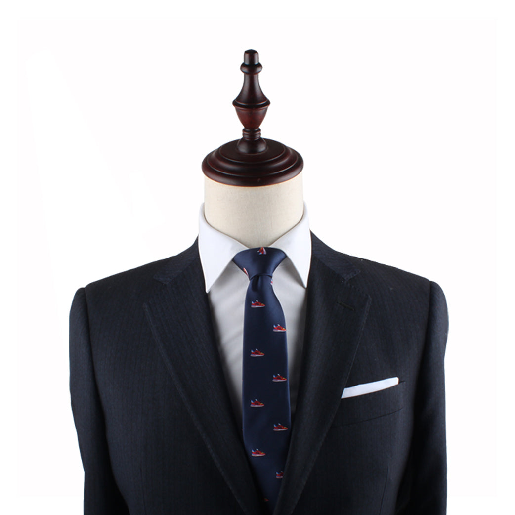 A black mannequin dressed in a dark suit, white dress shirt, and a Sneaker Slim Tie exudes modern style and urban flair.