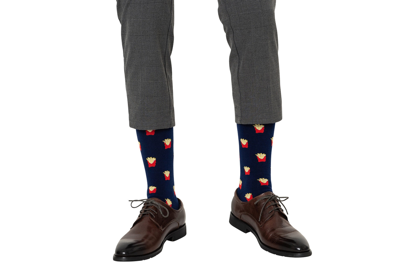 Someone wearing gray dress pants, dark brown dress shoes, and Fries Socks featuring a realistic yellow and red fries print.