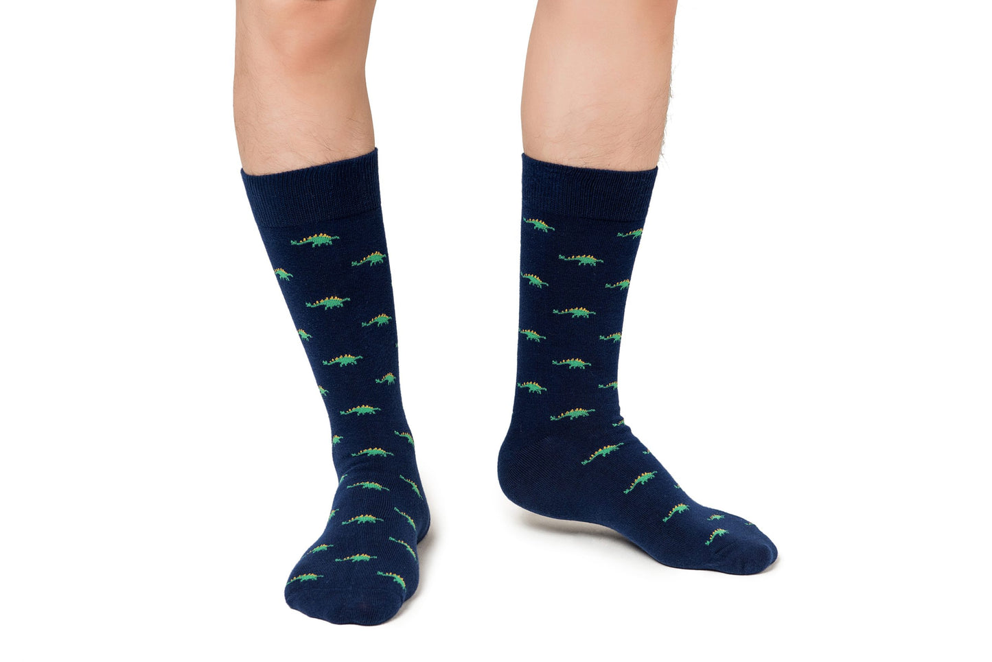 A person standing in Stegosaurus Socks with a whimsical green alligator pattern, isolated on a white background.