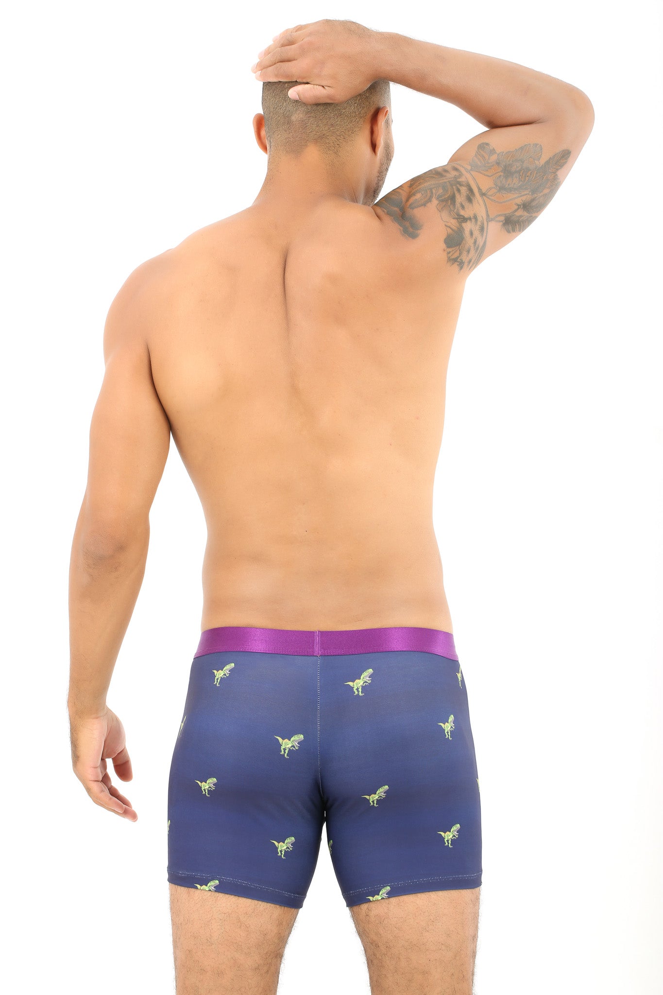 A shirtless person stands with their back to the camera, showcasing roaring comfort in T-Rex Underwear with a dinosaur pattern.