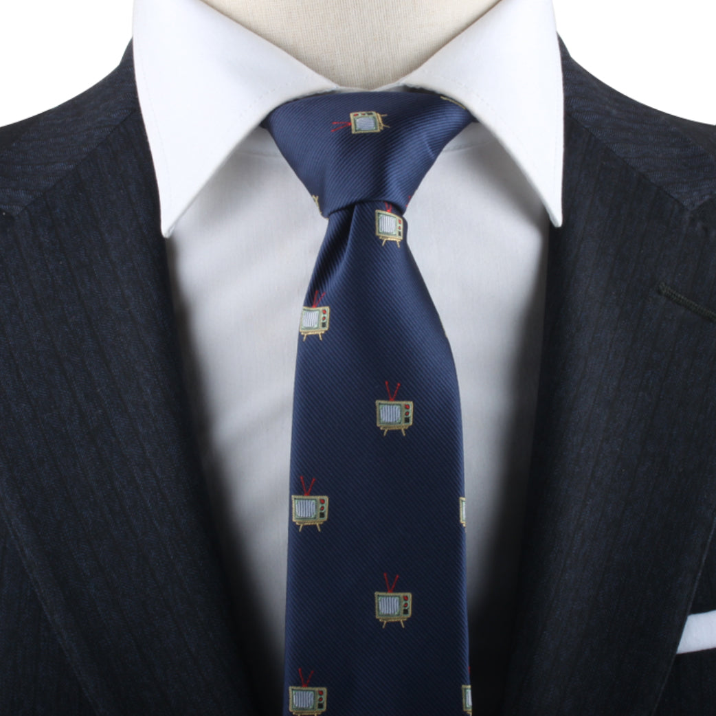 A close-up of a person wearing a white dress shirt, a dark suit jacket, and the TV Necktie adorned with small television screen patterns, blending elegance with hints of entertainment.
