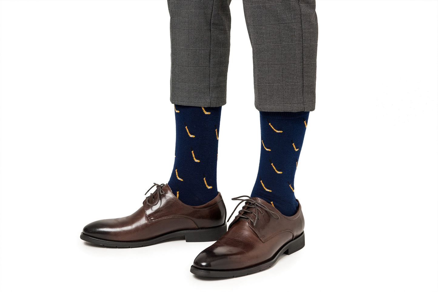 A pair of legs wearing brown shoes and Ice Hockey Socks.