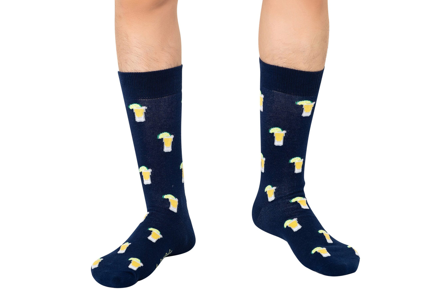 A person wearing Tequila Socksânavy blue party socks featuring a repeating pattern of beer mugs and foamâstands on a white background.