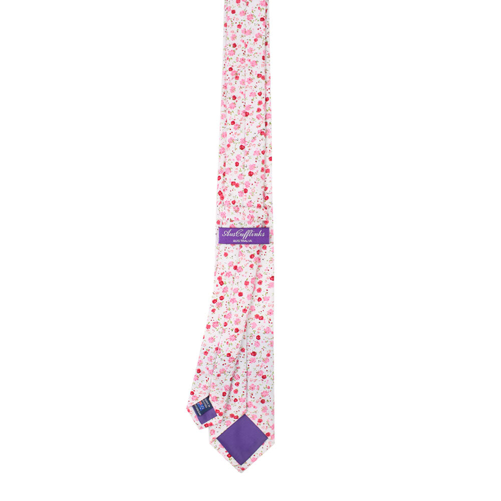 A graceful necktie from the Tonal Pink Azalea Floral Cotton Skinny Tie & Pocket Square Set, inspired by azaleas with a floral pattern in pink and white tones, featuring a purple label on the back.