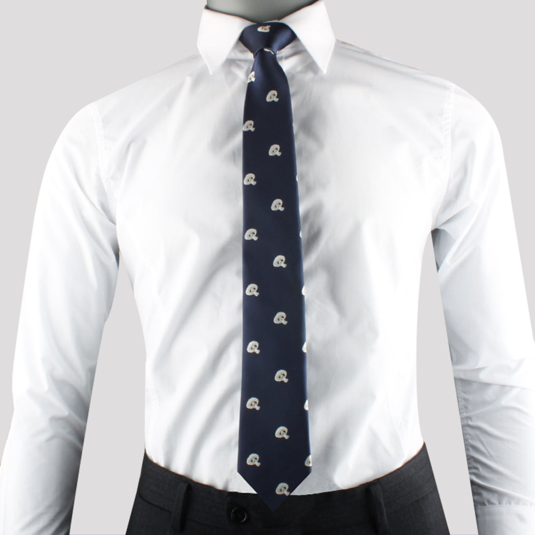 A person wearing a white dress shirt, dark slacks, and the stylish Trippy Mushroom Tie adorned with a small repeated pattern exudes elegance. The plain, light gray background accentuates their refined appearance.