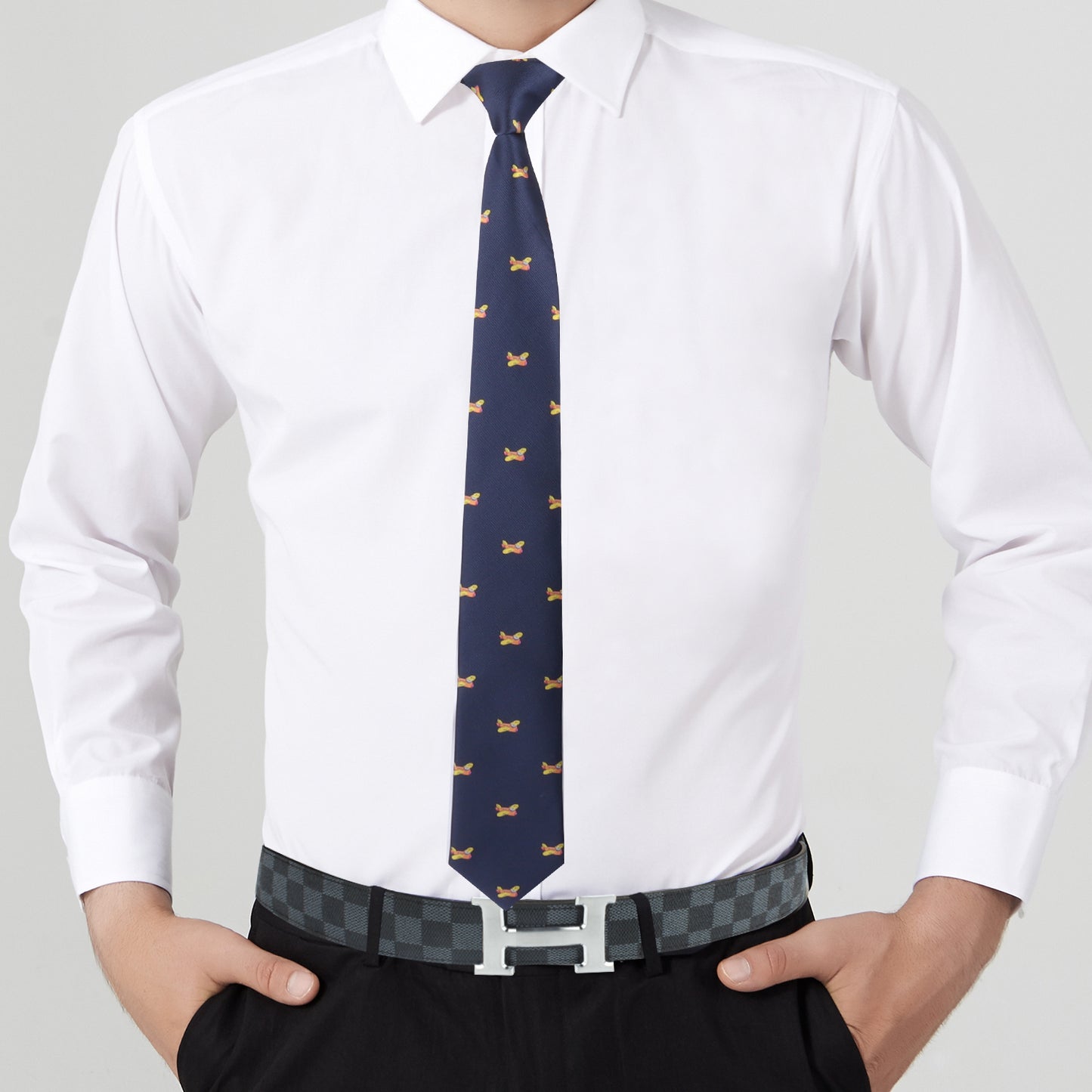 A person in a white dress shirt, complemented by the Vintage Aircraft Tie, effortlessly showcases their style. Their ensemble, featuring black pants and a checkered belt, is subtly enhanced by vibrant hues in the accessories, making for a truly eye-catching look.