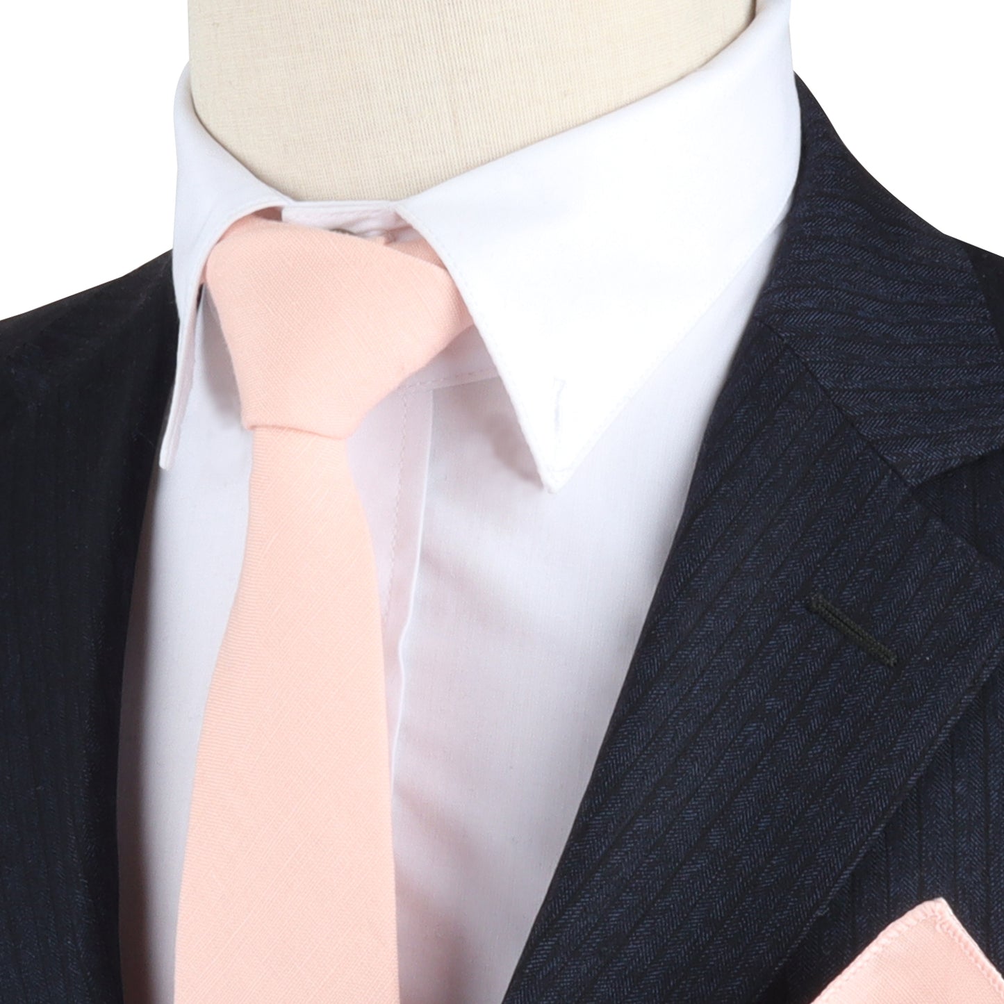 Close-up of a mannequin dressed in a dark pinstripe suit with a white shirt and a Baby Pink Skinny Tie, exuding woven charm.