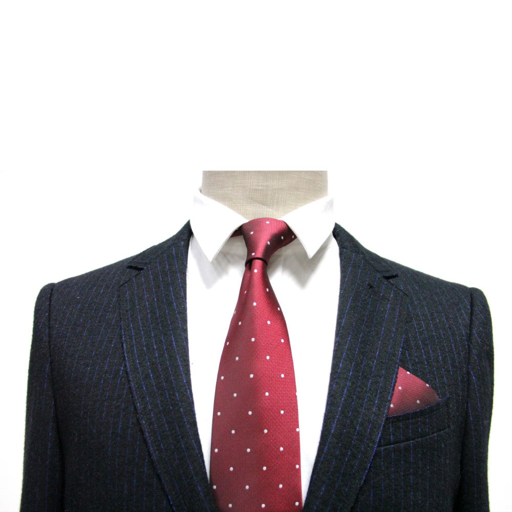 A mannequin wearing a dark pinstriped suit, white dress shirt, and a festive red and white polka dot tie paired with the Red White Polka Dot Pocket Square.