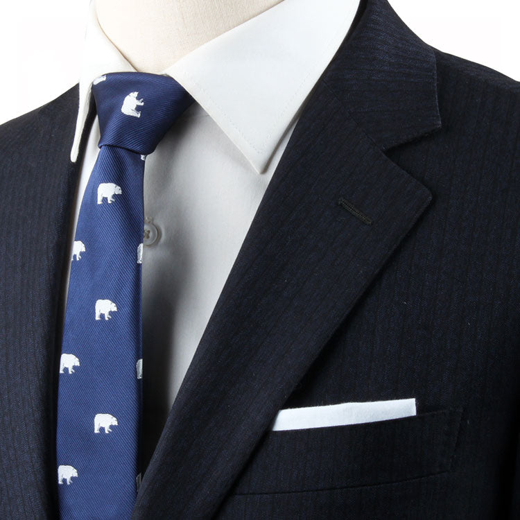 Close-up of a person wearing a dark suit jacket, white dress shirt, and a Winter Theme Tie. The ensemble radiates elegance, further complemented by a crisp white pocket square.
