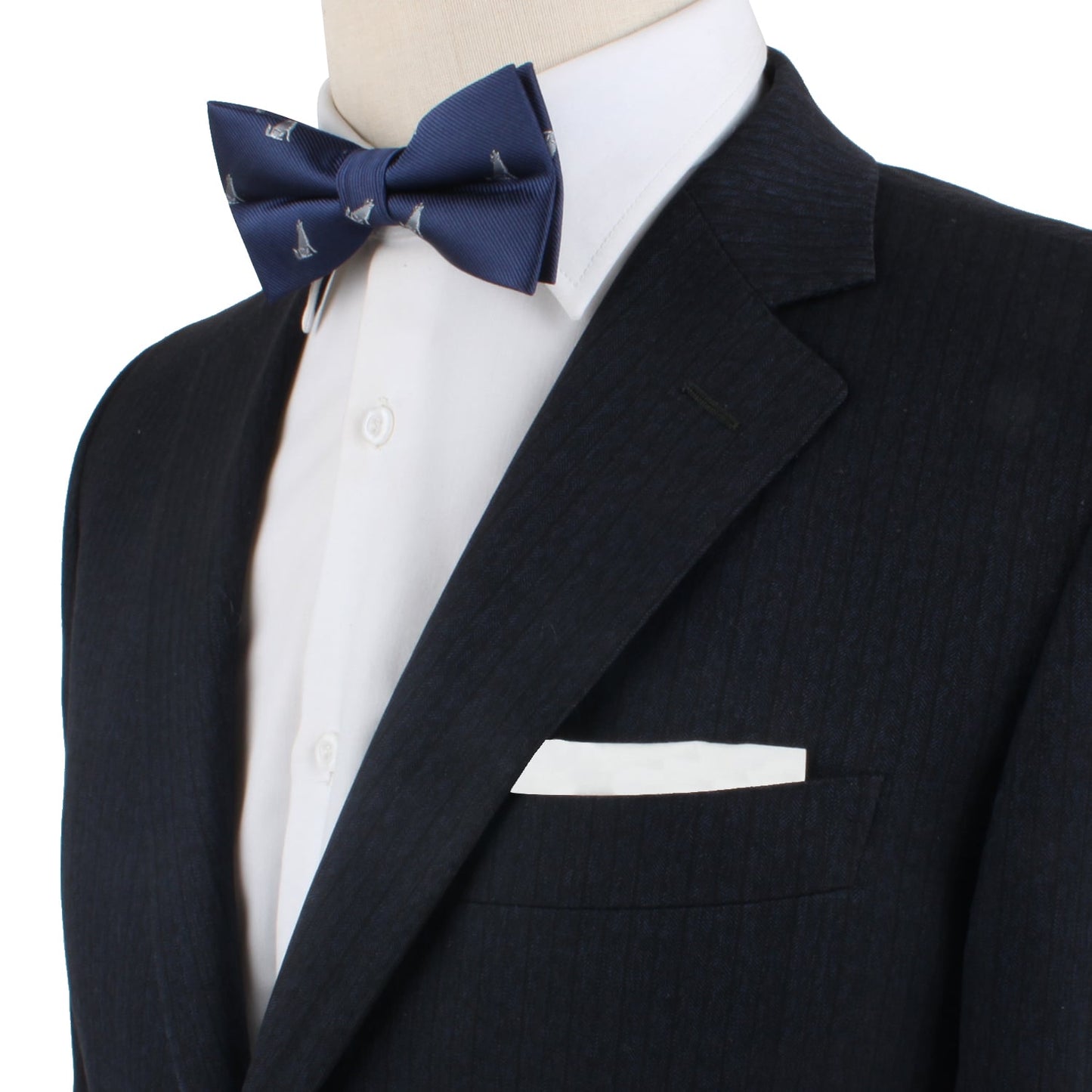 Wearing a dark pinstripe suit, an individual complemented their look with the Wolf Bow Tie, featuring small sailboat patterns, perfectly paired with a white dress shirt and pocket square.