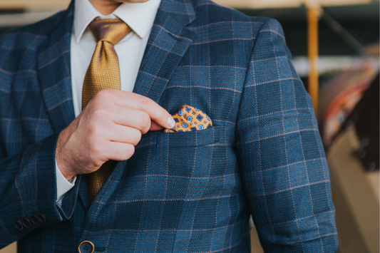 a man placing a pocket square in his suit