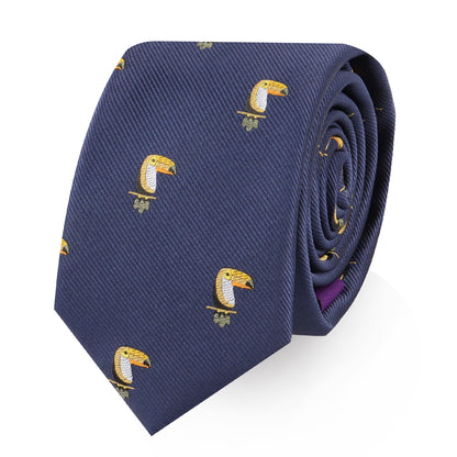 The Toucan Bird Skinny Tie is a rolled-up navy blue necktie featuring a repeating embroidered yellow toucan pattern—a unique tropical bird accessory and perfect gift for bird lovers.