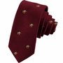 The Horse Racing Skinny MAROON Tie features a repeating embroidered bee pattern and is displayed rolled up against a white background.