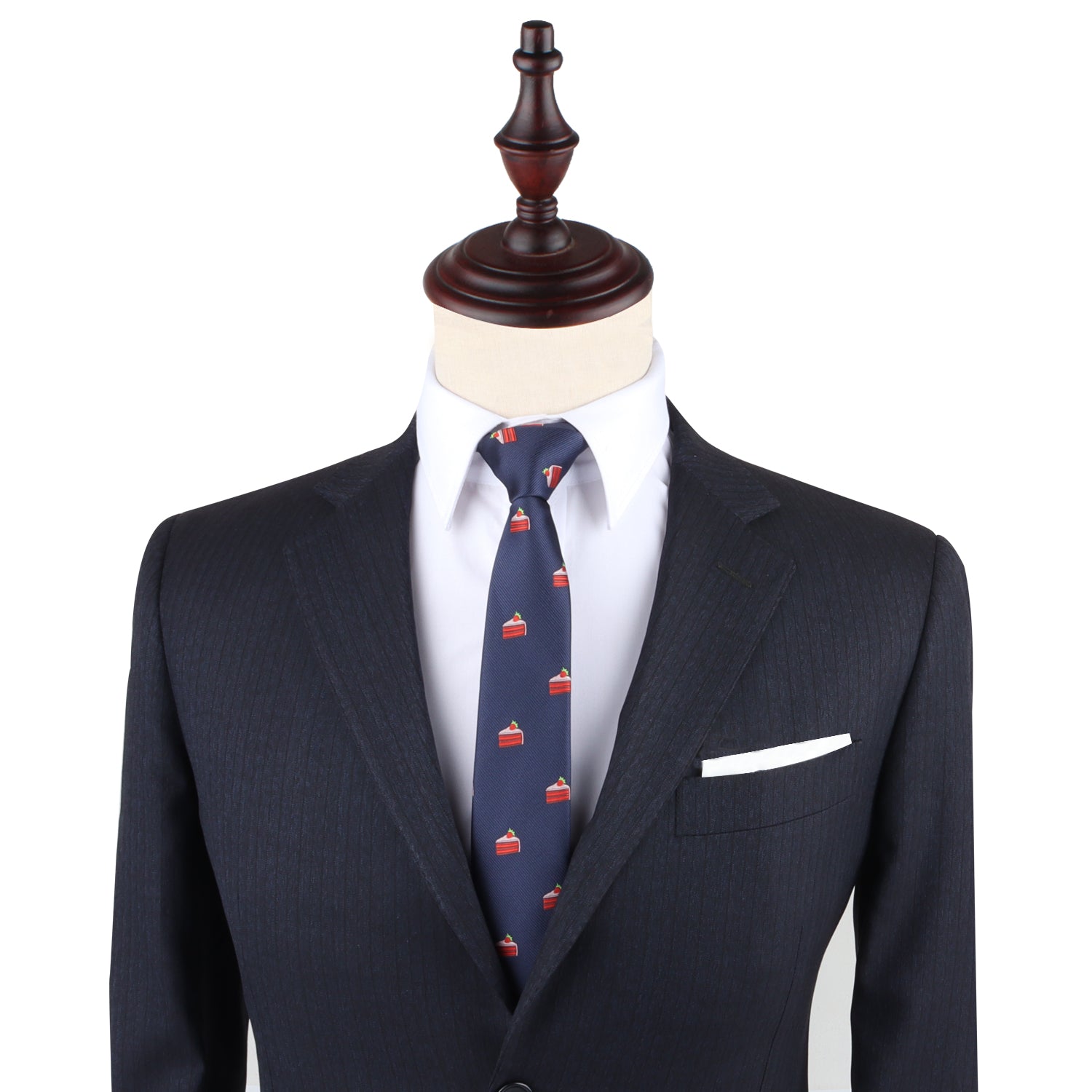 A mannequin dressed in a dark pinstripe suit, white dress shirt, Strawberry Cake Skinny Tie featuring playful dessert prints, and a white pocket square.