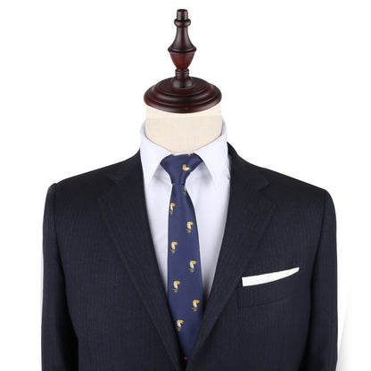 A dark suit jacket, white dress shirt, and Toucan Bird Skinny Tie are displayed on a mannequin with a wooden stand; a white pocket square adds flair—making this tie a perfect unique gift for bird lovers.