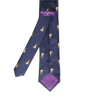 The Toucan Bird Skinny Tie features a navy blue background with yellow and white faucets, plus a purple brand label and tip lining—a quirky accent or fun gift, perfect for fans of unique toucan bird ties.