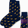 The Banana Socks, featuring a pattern of small yellow bananas on a blue background, add a touch of fruity fun to your day, with packaging that reads "AusCufflinks Australia.