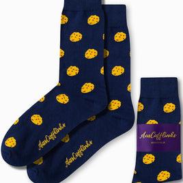 Cookie Socks in a dark blue color showcase a sugary design adorned with yellow polka dots and feature the "AusCufflinks" logo in gold text. Crafted for comfort, the packaging prominently emphasizes their Australian origin.