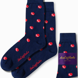 The Cricket Socks are a pair of sporty navy blue socks adorned with a pattern of small red and white cricket balls. They come with their packaging label, making them ideal for any occasion.