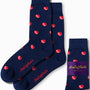 The Cricket Socks are a pair of sporty navy blue socks adorned with a pattern of small red and white cricket balls. They come with their packaging label, making them ideal for any occasion.