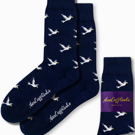 Dove Socks in navy blue, adorned with a pattern of white flying ducks, promise serene strides with every step and feature the "AusCufflinks" branding.