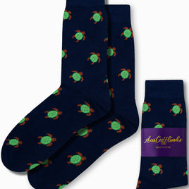 Green Turtle Socks in dark blue, embellished with an elegant pattern of green turtles. Displayed with one pair folded and labeled "AusCufflinks Australia.