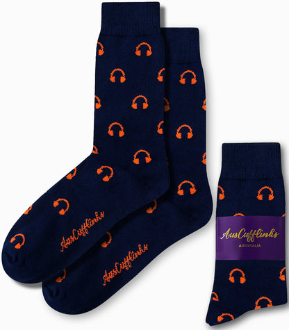 Introducing the Headphones Socks: navy blue socks adorned with an orange headphone pattern that blend style and comfort effortlessly. Showcasing the "AUS Cufflinks Australia" branding on both the side and packaging, these socks strike a perfect chord in your wardrobe ensemble.