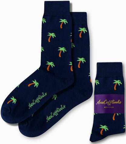 The Palm Tree Socks in navy blue feature scattered green and orange palm tree patterns that evoke tropical vibes, and are perfectly complemented by their matching packaging.