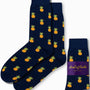 The Pineapple Socks feature a tropical design with vibrant yellow pineapples on a navy blue background, providing comfort from heel to toe and accented with a chic purple label.